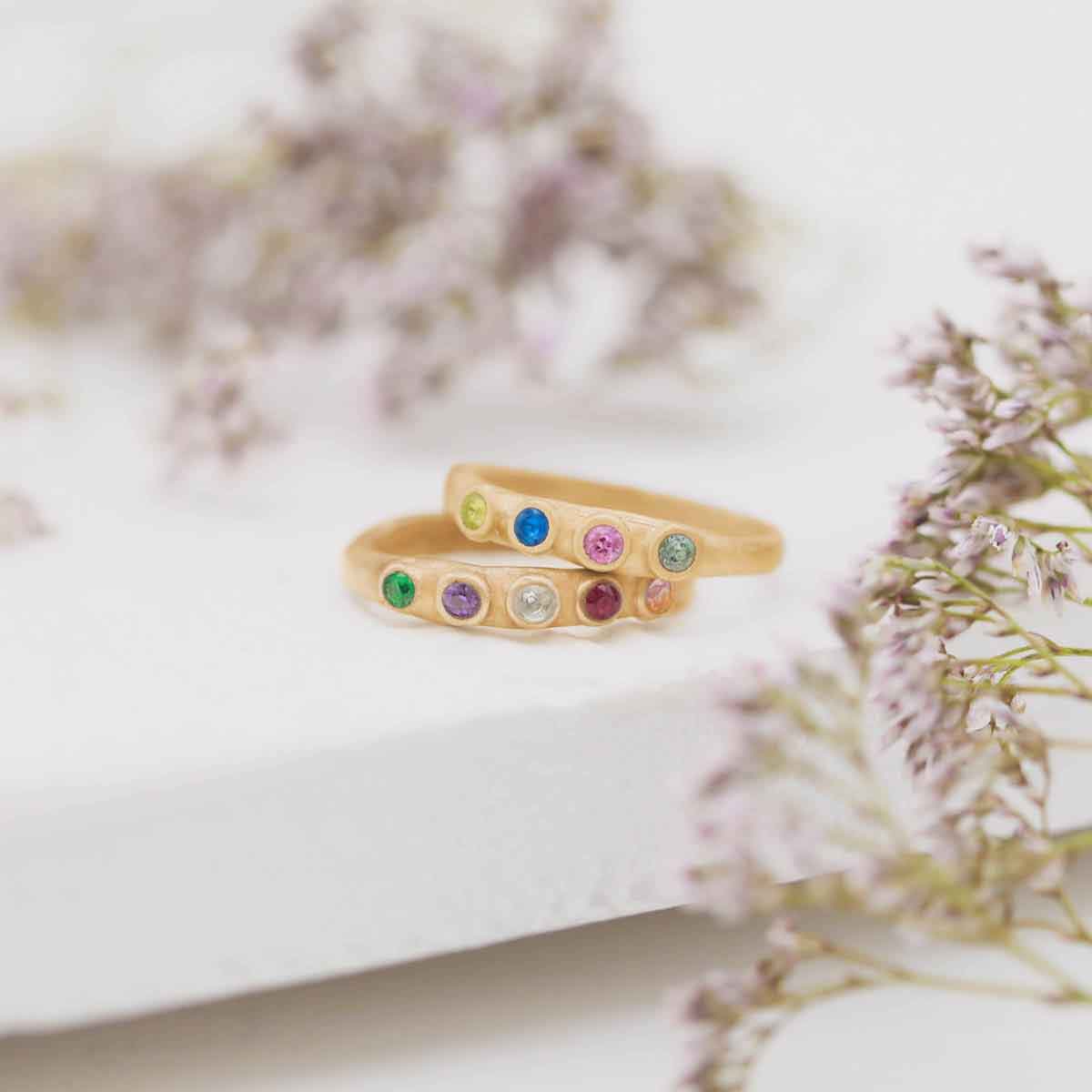 Handcrafted 10k yellow gold mother's rings customizable with up to 6 genuine birthstones along with other gold stacking rings