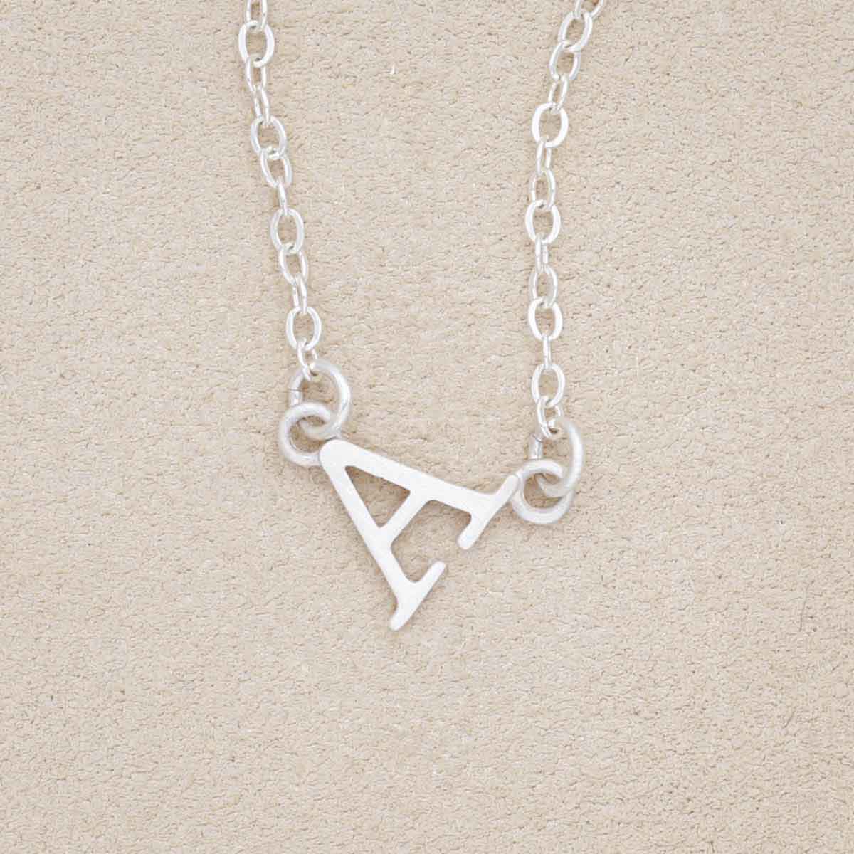 sterling silver my monogram letter necklace on beige background