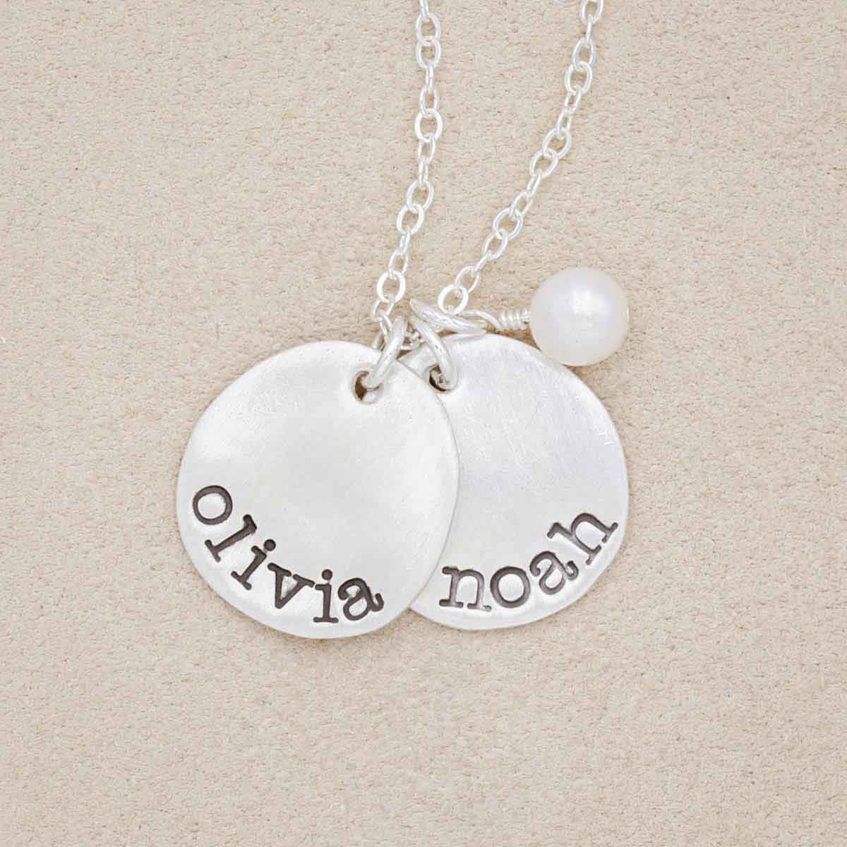 sterling silver petite mother's necklace with personalized charms and freshwater pearl, on beige background