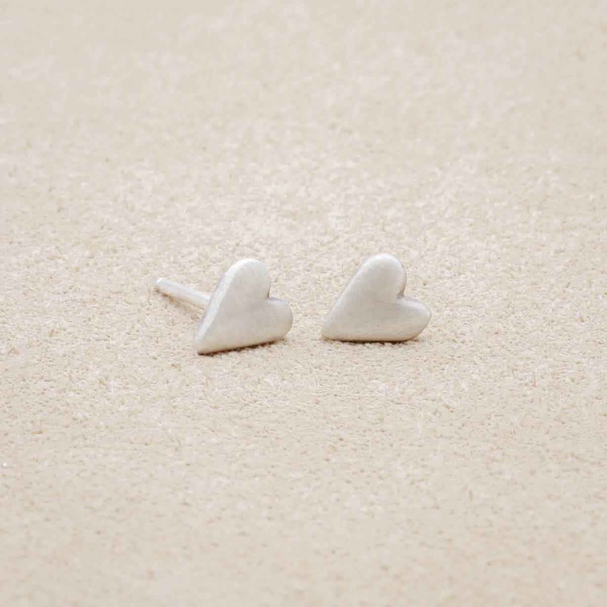 sterling silver tiny heart stud earrings with a matte brushed finish