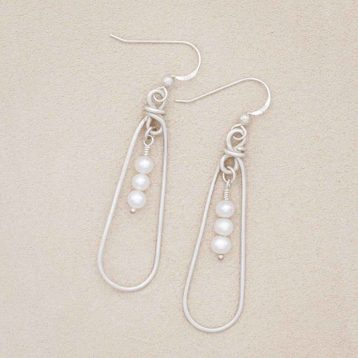 a mother's love pearl sterling silver earrings on marble background