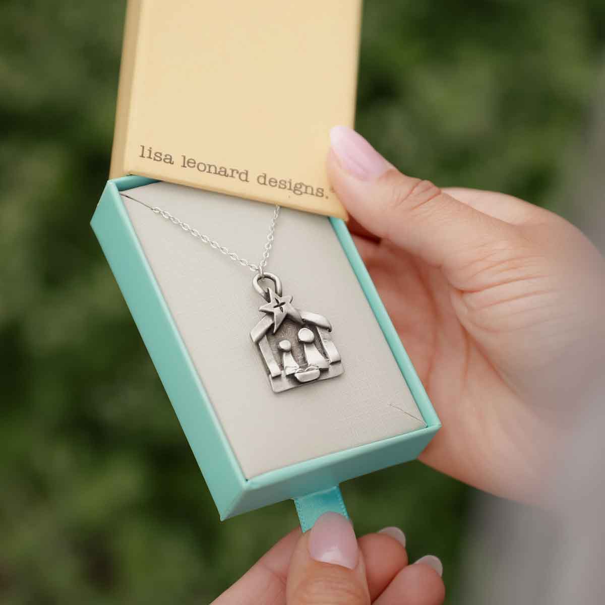 Girl holding a Savior is Born Nativity Necklace