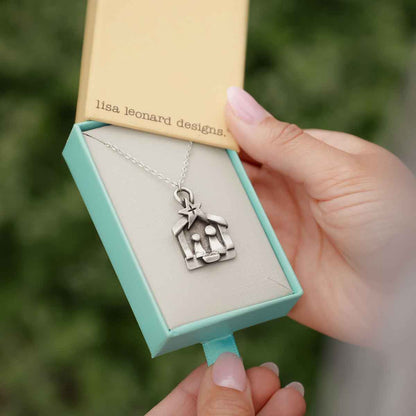 Girl holding a Savior is Born Nativity Necklace