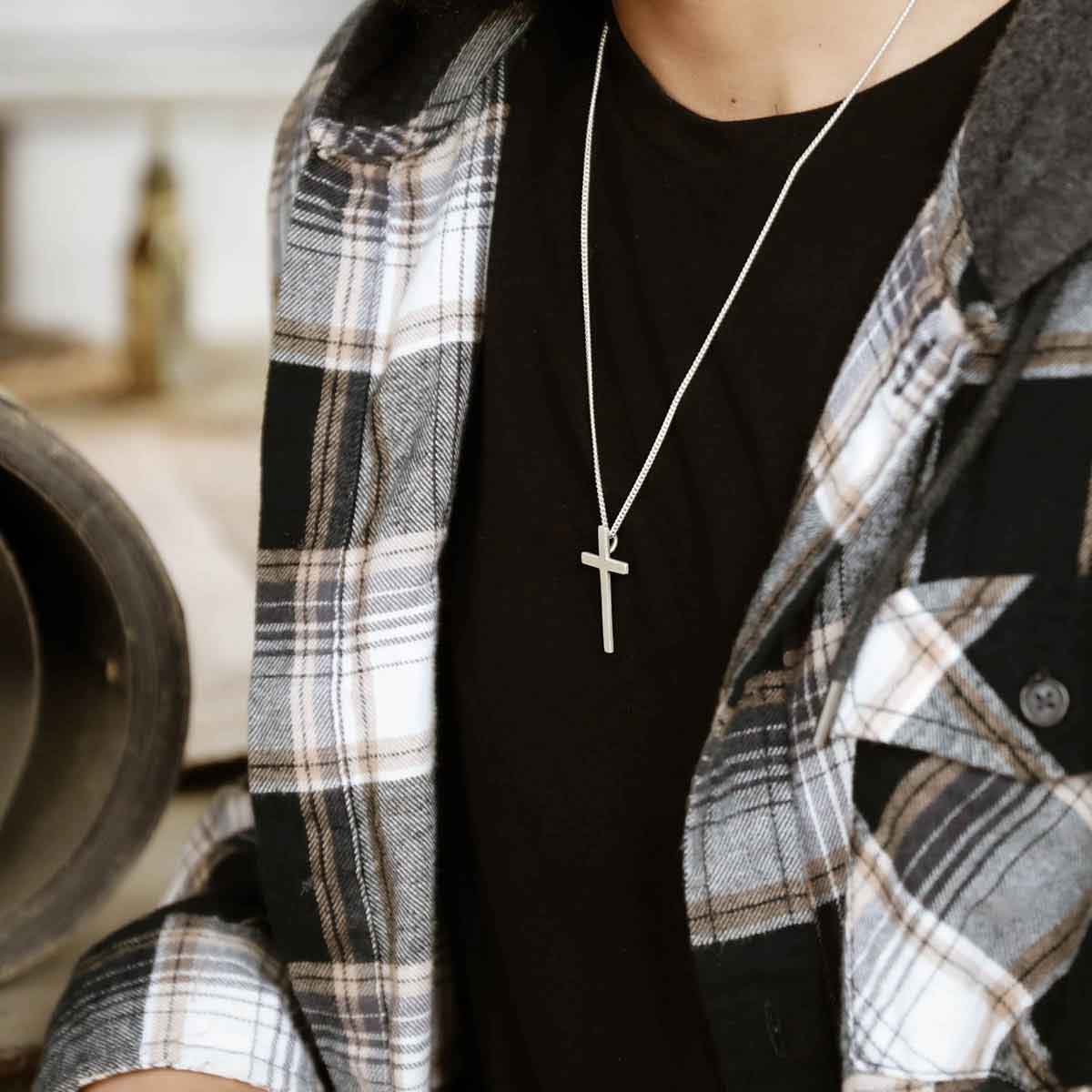 man holding a sterling silver Beloved Cross necklace