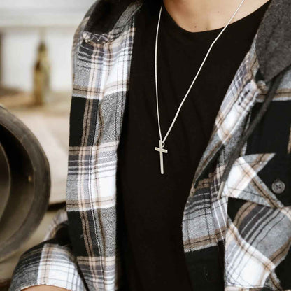 man holding a sterling silver Beloved Cross necklace