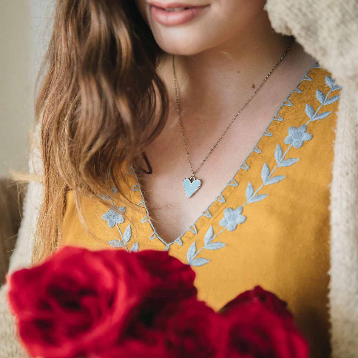 Girl wearing her Brave Love heart necklace handcrafted in pewter with choice of color epoxy