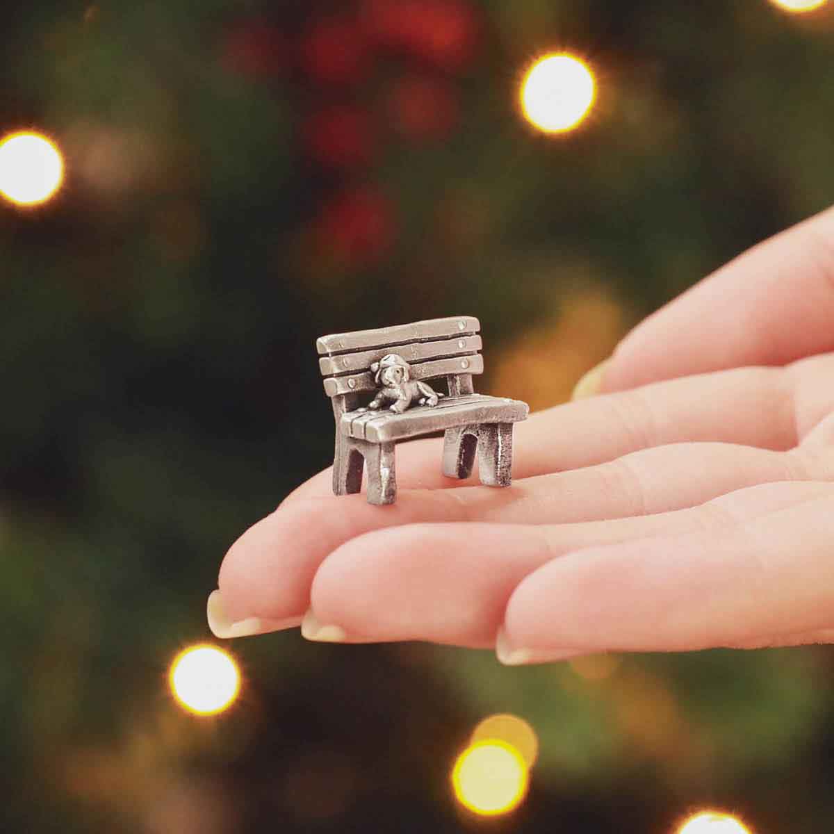 hand holding The Carolers Christmas Village Collection decorated with fake snow