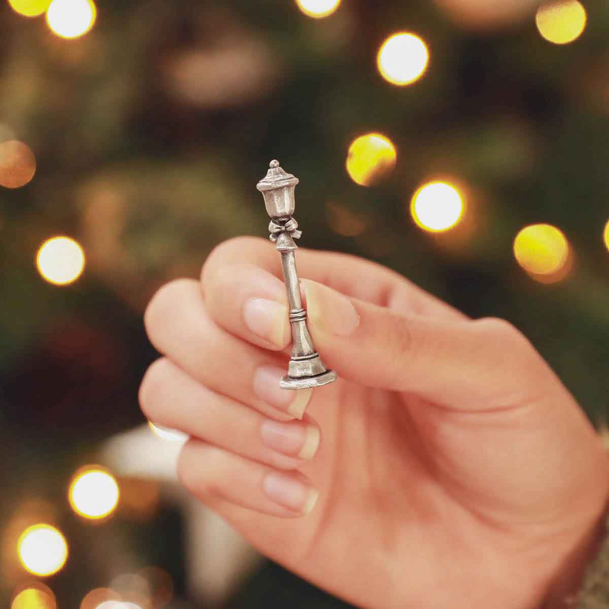 hand holding the bench with a puppy on it from The Carolers Christmas Village Collection