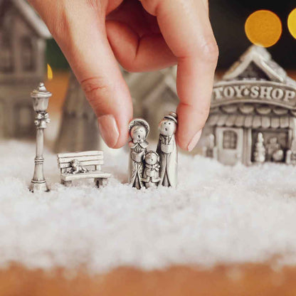 hand holding the family of carolers from The Carolers Christmas Village Collection