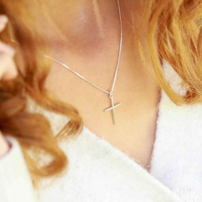 woman holding a sterling silver Covenant of Love Cross necklace