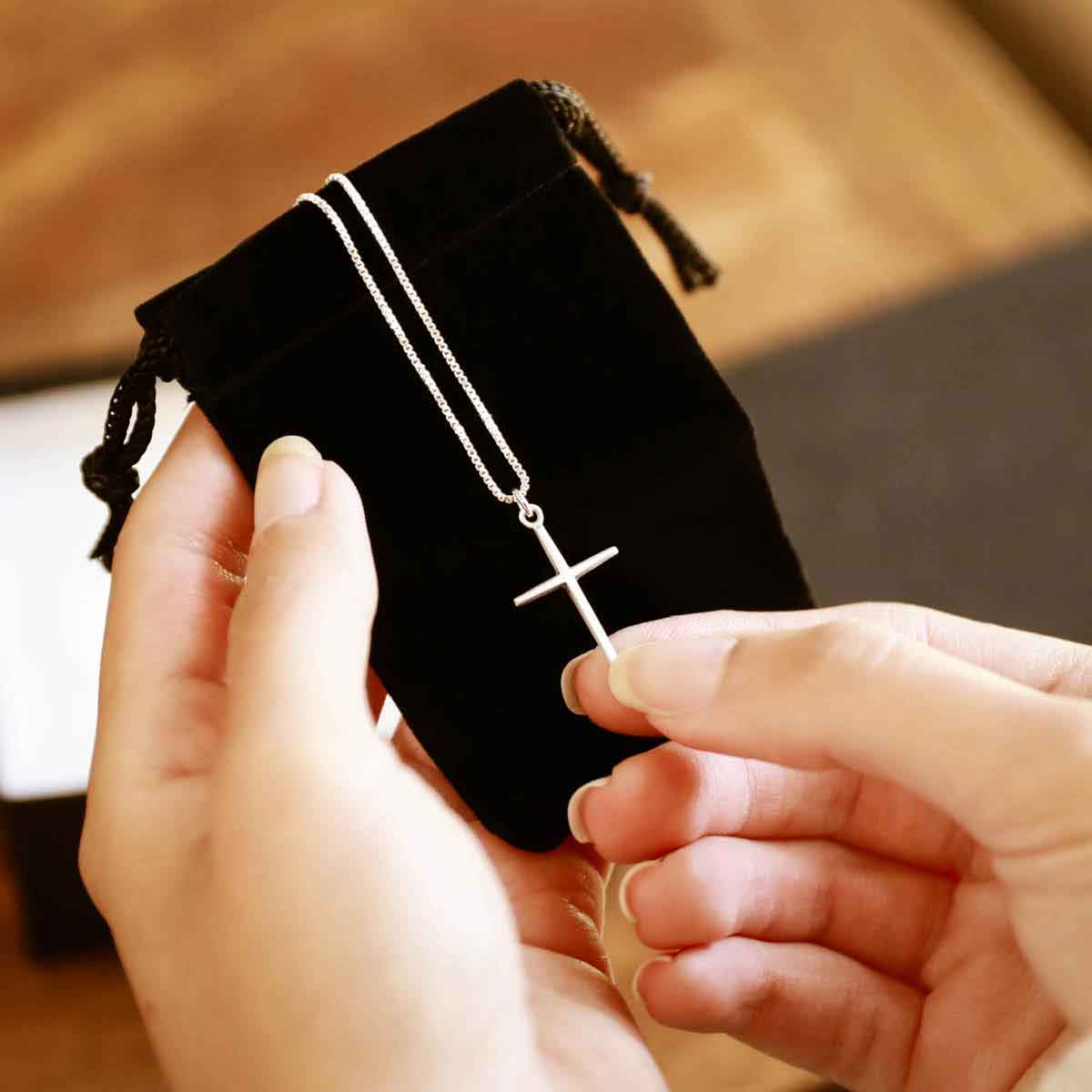 woman holding a sterling silver Covenant of Love Cross necklace