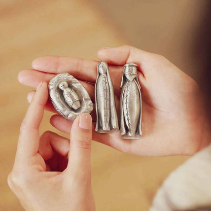 hands holding the pewter holy family nativity figurine set