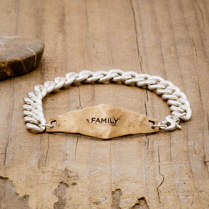 Identity Bracelet with a personalized Bronze metal plate and Sterling Silver chain, on wood background 