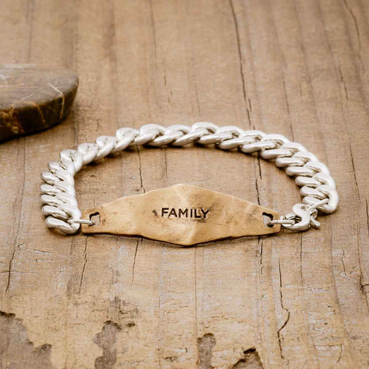 Identity Bracelet with a personalized Bronze metal plate and Sterling Silver chain, on wood background 