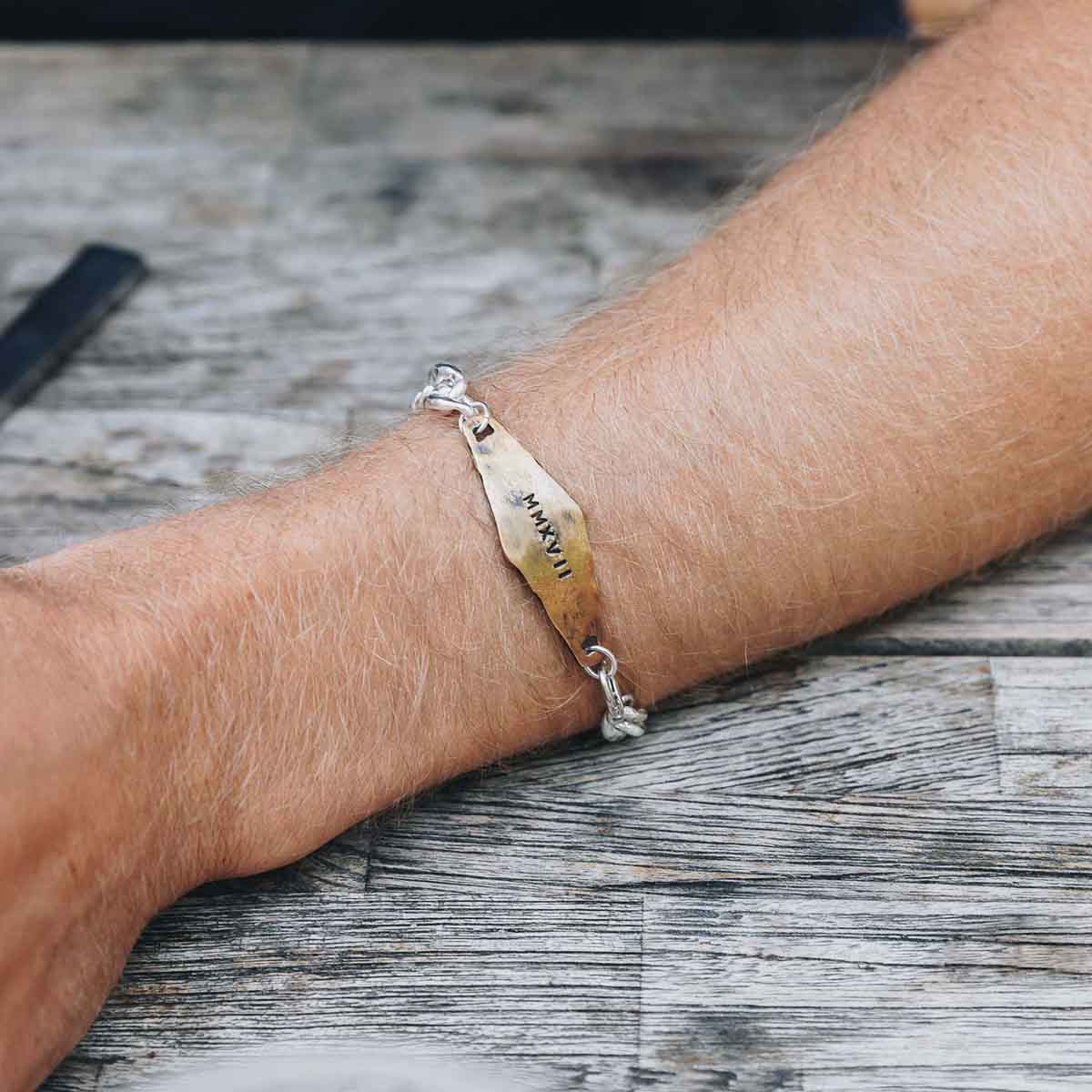 man wearing the Identity Bracelet with a personalized Bronze metal plate and Sterling Silver chain