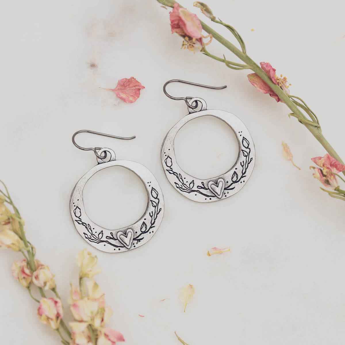 pewter let love grow hoop earrings on marble background with pink flowers