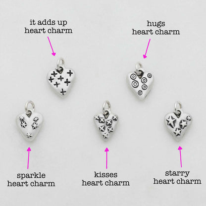 Light + Bright hearts charms handcrafted in sterling silver with a matte brushed finish and the heart charm hung next to a vintage freshwater pearl