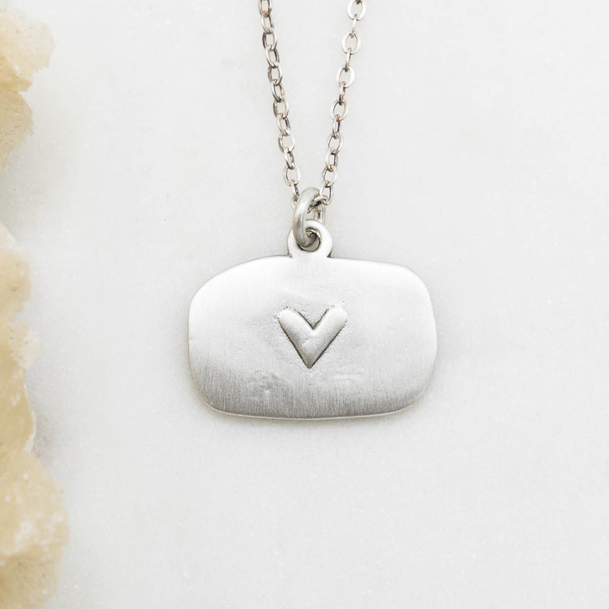 Love and Wildflowers necklace handcrafted in sterling silver including charm with a matte brushed finish and a heart engraving