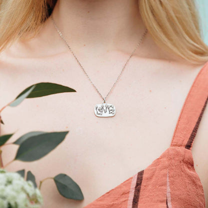 Woman wearing her Love and Wildflowers necklace handcrafted in sterling silver including charm with a matte brushed finish