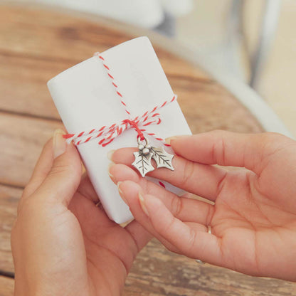 our Christmas tradition advent ornament set handcrafted and cast in fine pewter with one tied around a Christmas present