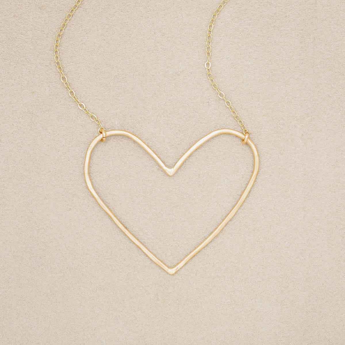 Gold filled Peaceful Heart Necklace on suede background