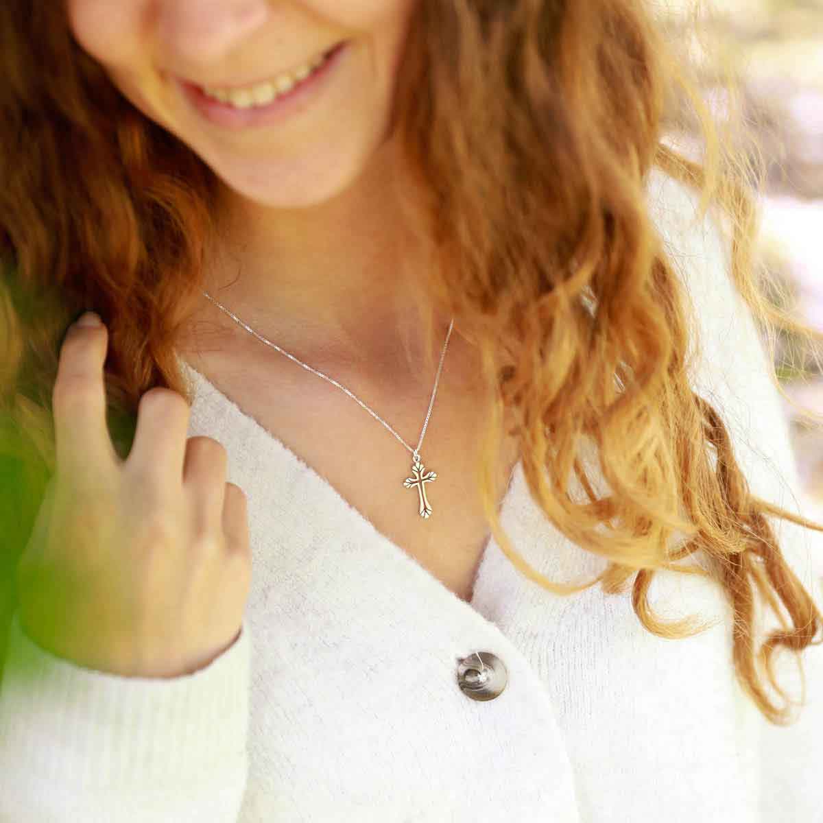 woman holding a sterling silver Resurrection Cross Necklace