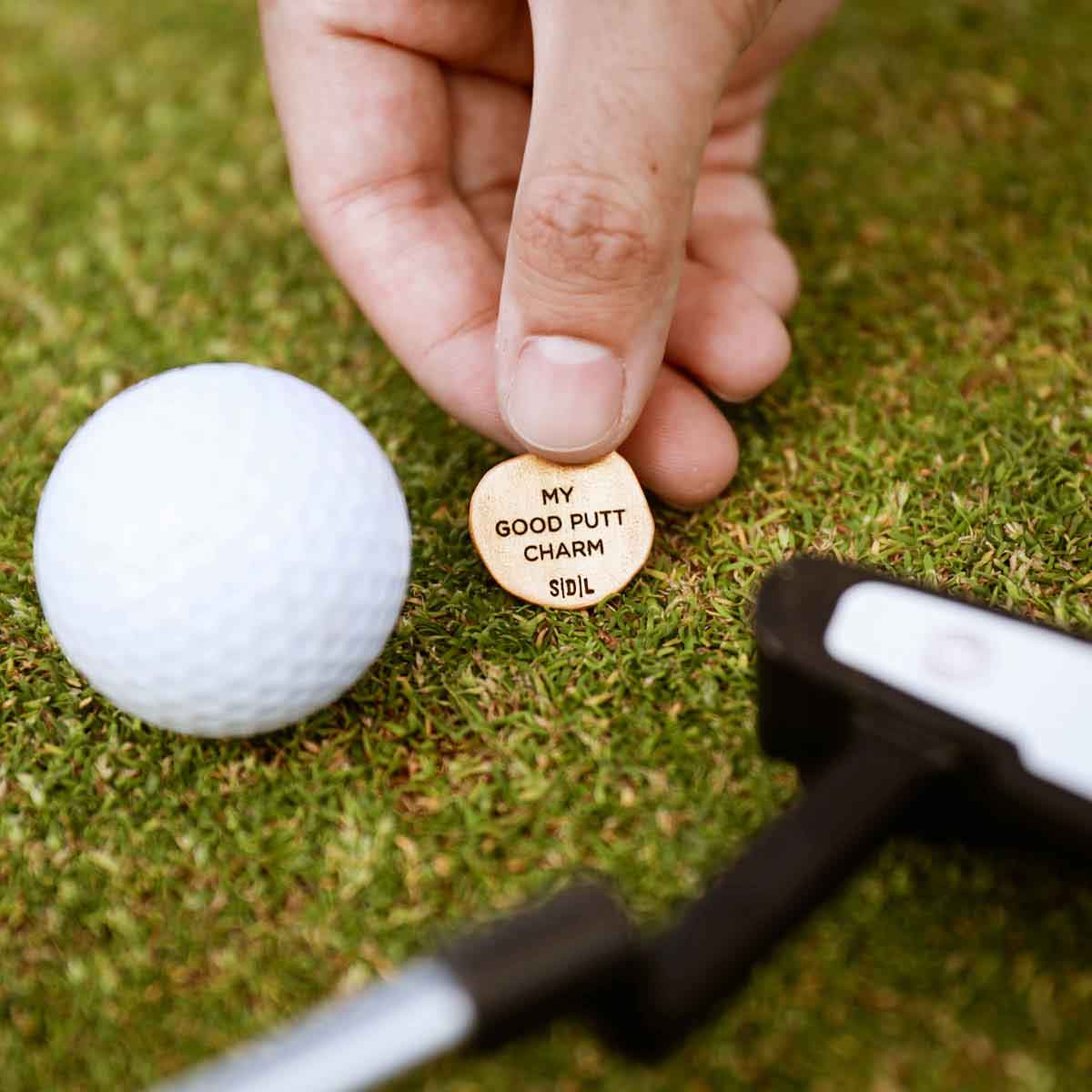 hand holding Personalized Bronze Roman Cross Coin Golf Ball Marker