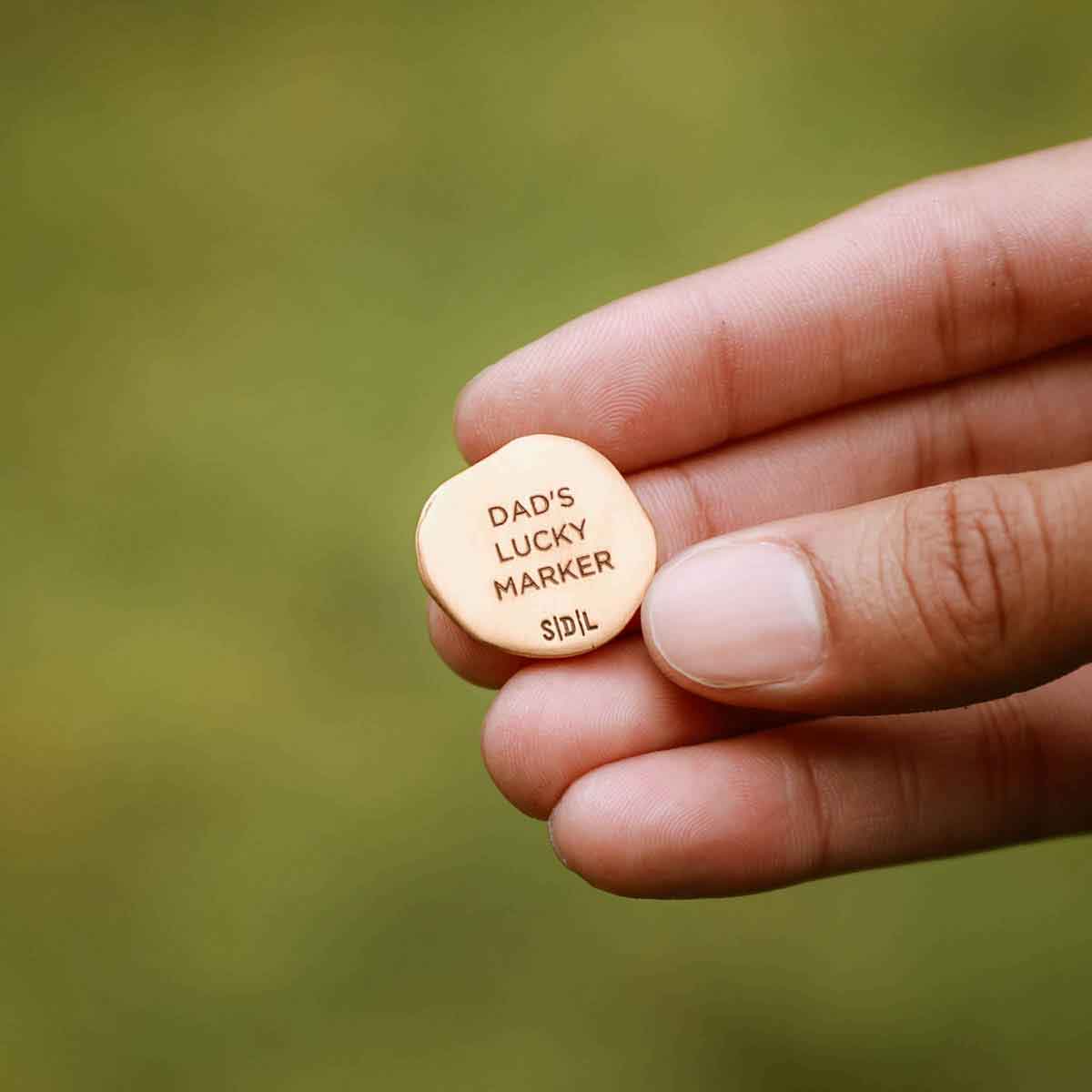 hand holding personalized Bronze Roman Cross Coin Golf Ball Marker