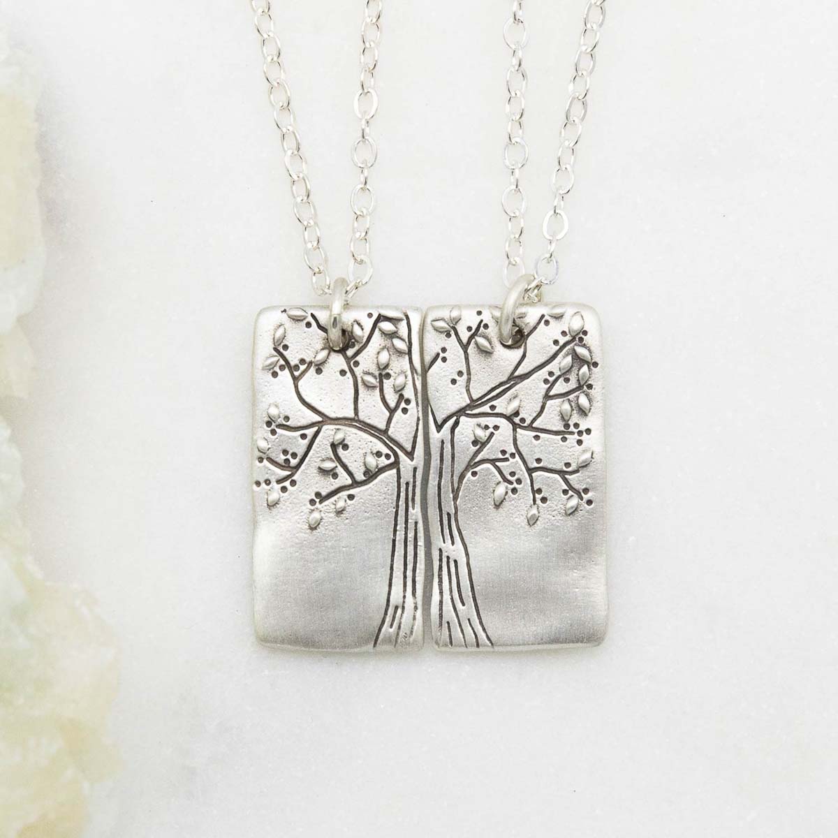 sterling silver rooted in love necklace set, on a white marble background