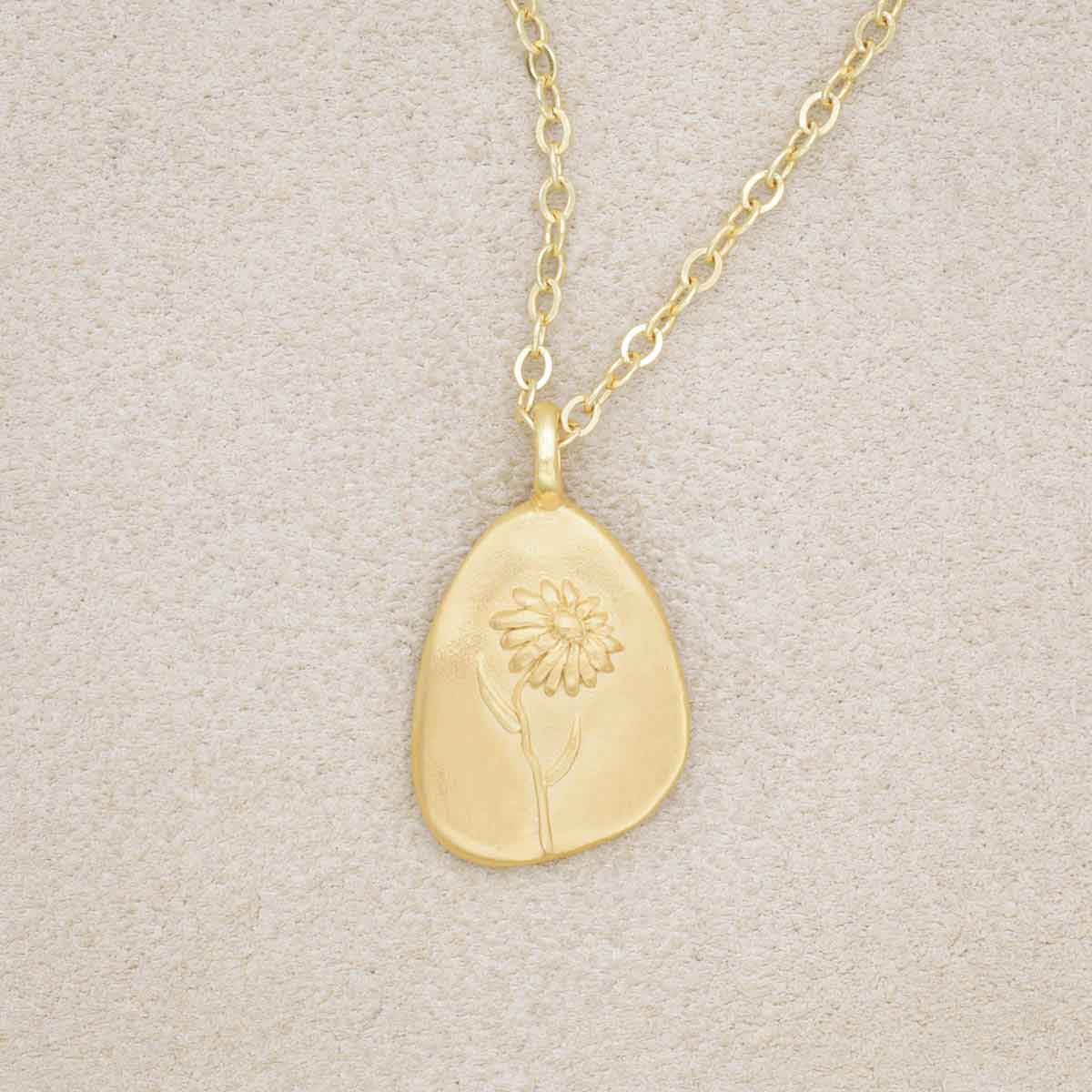 gold plated September birth flower necklace with an 18" gold filled link chain, on beige background