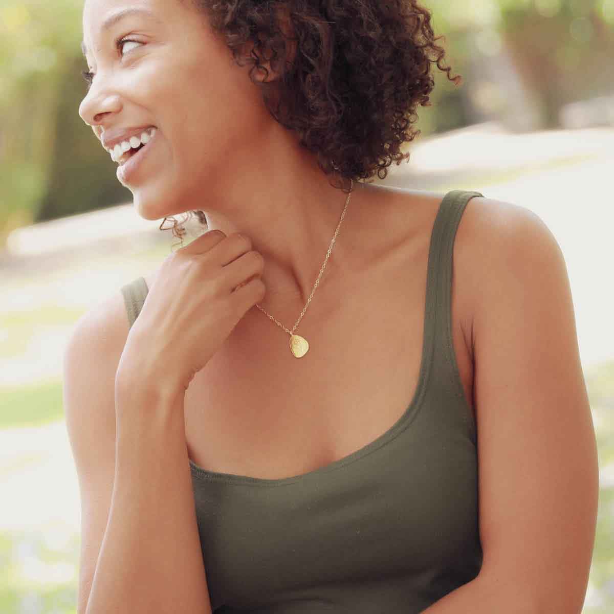 girl holding a gold plated September birth flower necklace with an 18" gold filled link chain