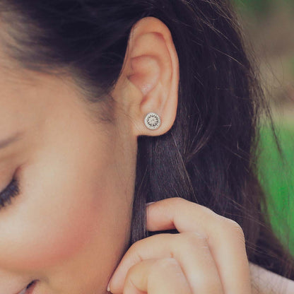 woman wearing pair of sterling silver sunburst stud earrings with a matte-brushed finish with 3mm crystals 