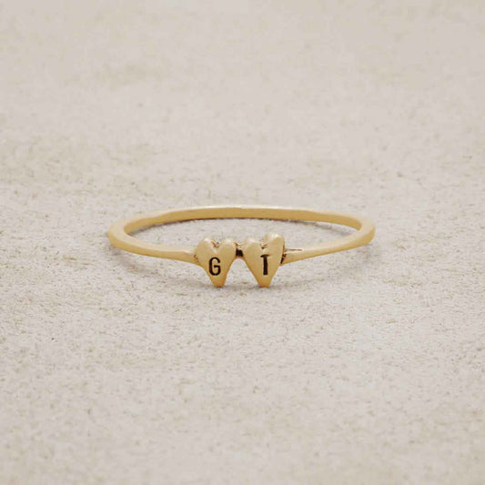 14k yellow gold Sweet Love Initial Ring - Two Hearts, personalized with two initials, on a beige background